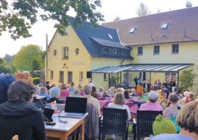 Viele Menschen sitzen in einem Freiluft-Gottesdienst im Gelände der Begegnungsstätte Sonnenhofn