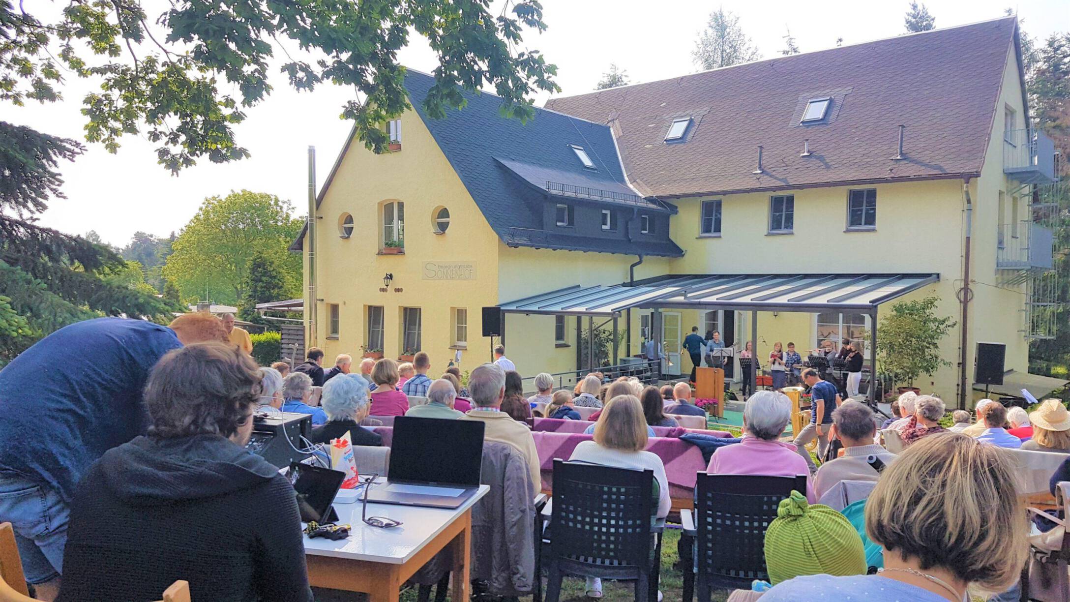 Viele Menschen sitzen in einem Freiluft-Gottesdienst im Gelände der Begegnungsstätte Sonnenhofn